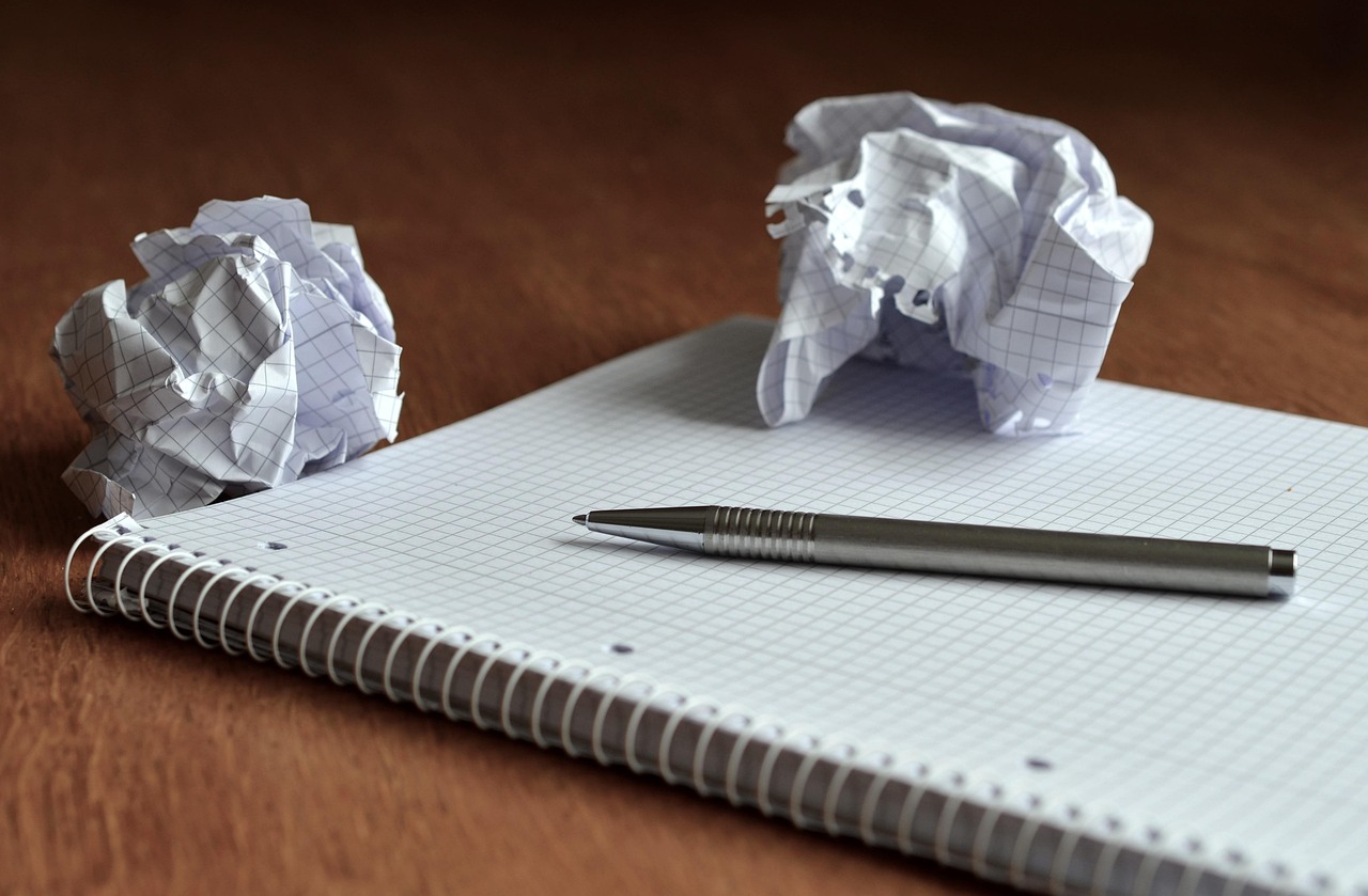 Person drawing flowchart steps and conceptual connections in a notebook